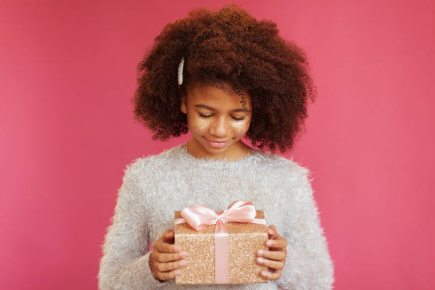 istock Cute festive girl holding a shiny gift box 1186914791
