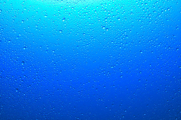 istock Blue glass surface with clear water drops, background 1186914861