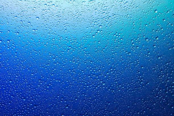 istock Water droplets on a translucent rainbow glass background with gradient 1186914947