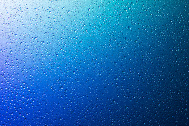 istock Water droplets on a translucent rainbow glass background with gradient 1186915012
