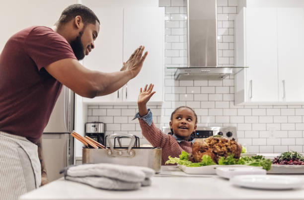 พ่อและลูกสาวแอฟริกันอเมริกันเตรียมอาหารค่ําวันขอบคุณพระเจ้า - family dinners and cooking ภาพสต็อก ภาพถ่ายและรูปภาพปลอดค่าลิขสิทธิ์