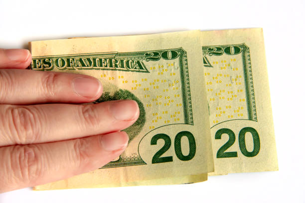 2020 written with dollars bank notes in a hand isolated on white background, new year greetings money concept
