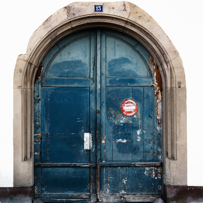 Strasbourg, Bas-Rhin / France - 10 August 2019: detail view of a large blue arched wooden doorway with a sign in French saying 