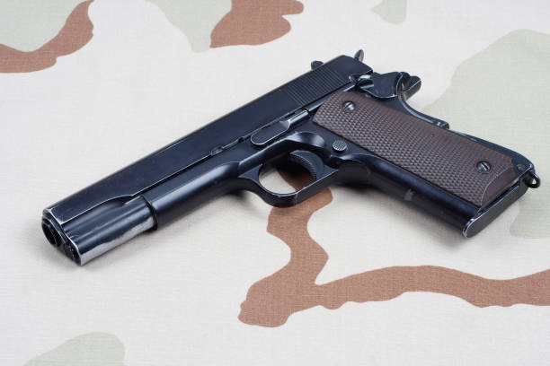 istock handgun on camouflage uniform 1186917240