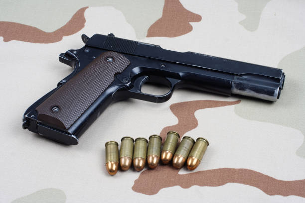 istock handgun on camouflage uniform 1186917344