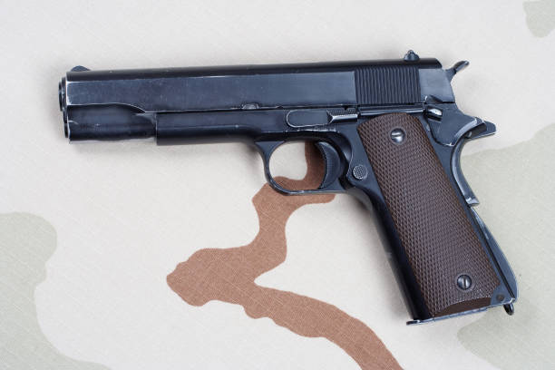 istock handgun on camouflage uniform 1186917368