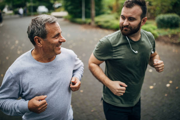 istock Father and son jogging together in a public park 1186920013