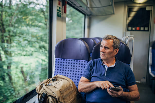 istock An old tourist uses a cellphone on a train 1186920075