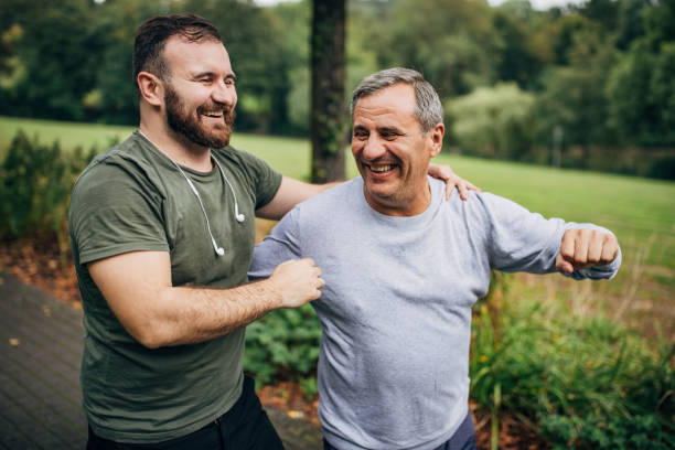 istock Father and son jogging together in a public park 1186920096