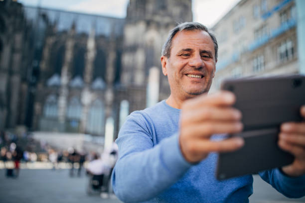 istock Senior tourist uses cellphone from city square 1186920100