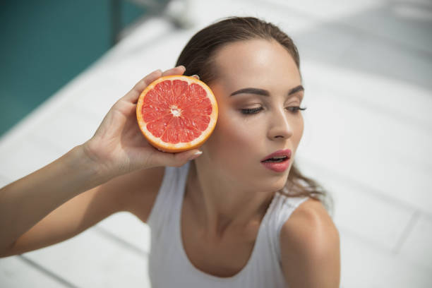 istock Pretty young lady holding grapefruit near the eyes 1186920116