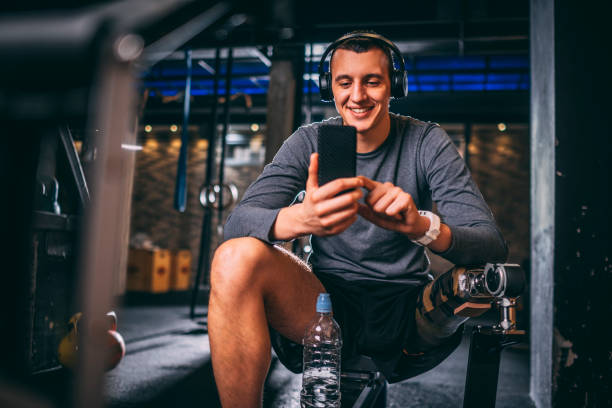 istock Young disabled athlete with a prosthetic leg having a video call on his mobile phone while training in a fitness gym 1186921860