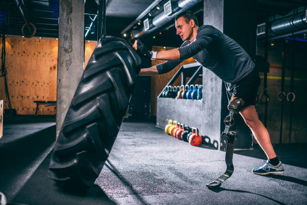 istock Adaptive young athlete doing a tire flip sport exercise in a gym 1186921908