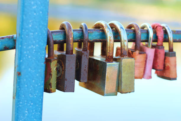 colored padlocks on the railing of the bridge over the river