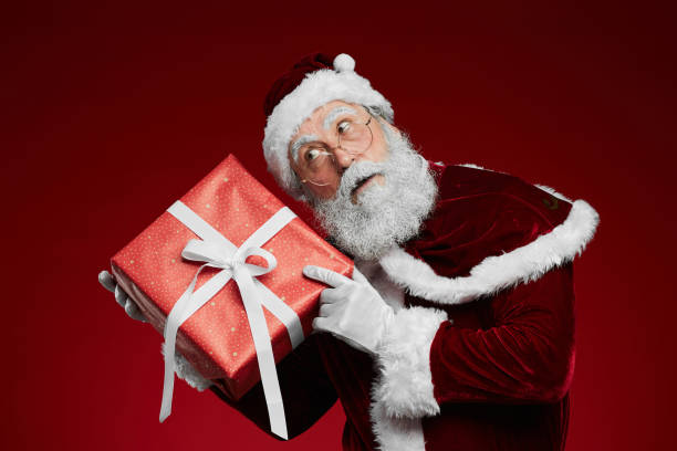 istock Santa Claus Holding Present 1186923349