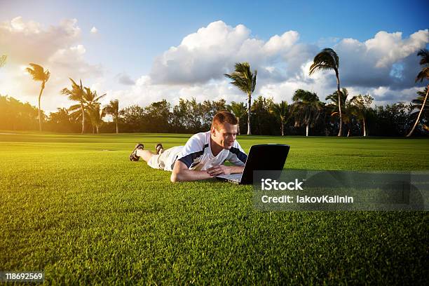 Young Man Whith Portátil En El Green Field Foto de stock y más banco de imágenes de Adulto - Adulto, Adulto joven, Aire libre