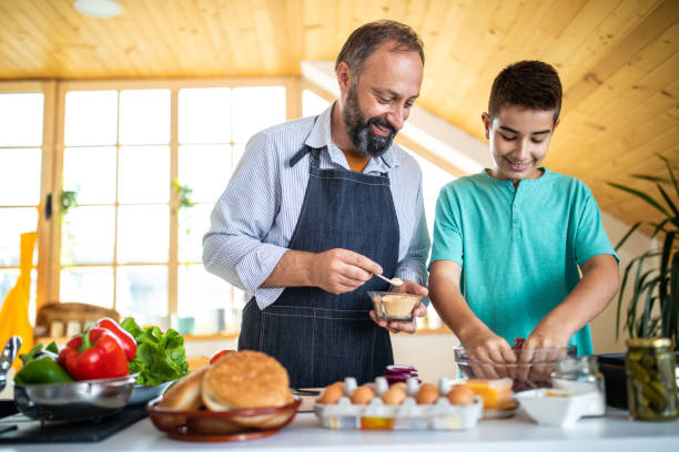 istock Teenage boy mixing ground beef at kitchen 1186928220