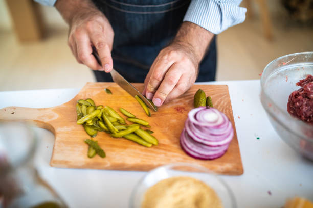 istock Chef cutting pickles and other vegetables on cutting board at kitchen 1186928270