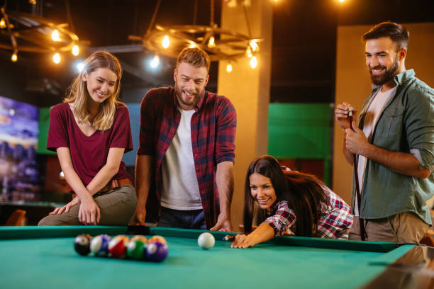 istock Group of friends having fun while playing pool in a local pool hall 1186930533