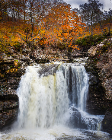 Falloch falls in October.Beautiful waterfall in autumn coloured woodland, in Scottish highlands.Majestic landscape of Scotland, UK.Popular tourists attraction.Beauty in nature.