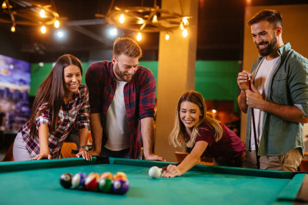 istock Group of friends having fun while playing pool in a local pool hall 1186931320