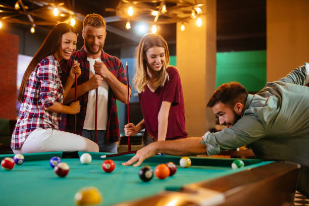 istock Group of friends having fun while playing pool in a local pool hall 1186932247
