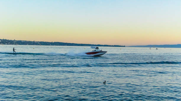 hombre wakeboarding en un hermoso lago de ginebra al atardecer. esquí acuático en el lago detrás de un barco. - wakeboarding motorboating extreme sports waterskiing fotografías e imágenes de stock