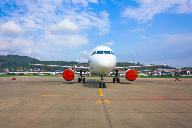 Passenger aircraft parked at the airport with covered red covers engines. Passenger aircraft parked at the airport with covered red covers engines turbojet engine photos stock pictures, royalty-free photos & images