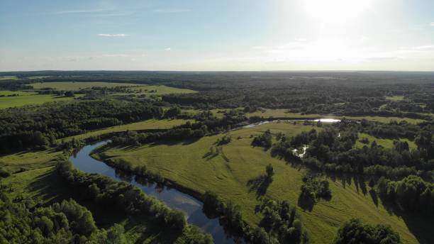 istock Top view of a winding small river flowing through green meadows 1186933635