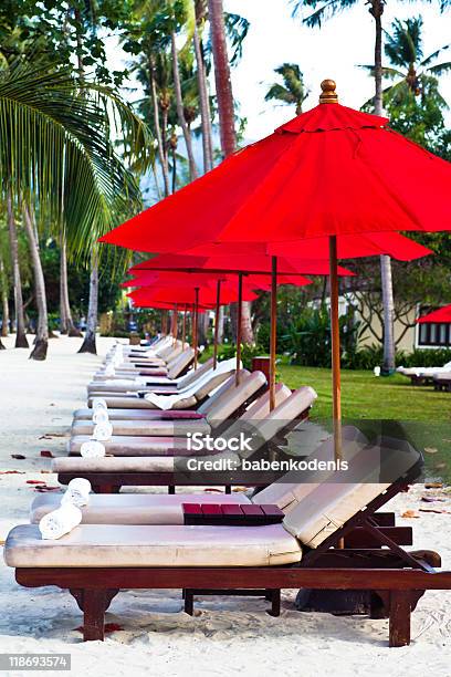 Rojo Sombrillas Y Sillas Reclinables En La Playa De Arena En El Trópico Foto de stock y más banco de imágenes de Playa