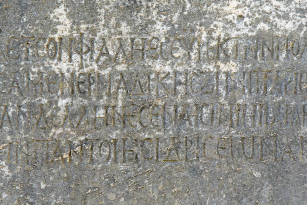 istock Half-erased ancient Greek letters embossed on an old gray marble slab covered with cracks 1186936441