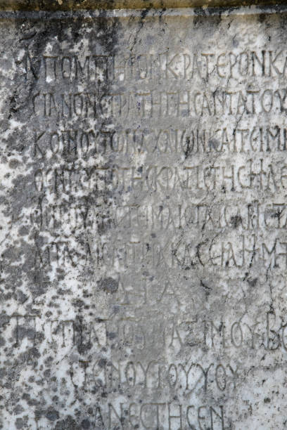 istock Half-erased ancient Greek letters embossed on an old gray marble slab 1186937137