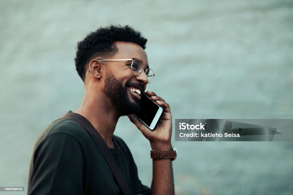 Success came calling at the right time Shot of a handsome young creative businessman talking on his cellphone outside in the city Using Phone Stock Photo