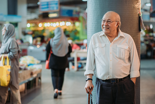 Active senior man waiting his friend during morning market shopping