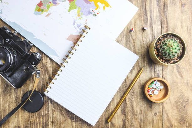 istock World map, pins with flags, retro camera, sunglasses, notepad, flower. Flat lay vacation travel planning composition. Travel photographer concept. 1186946559