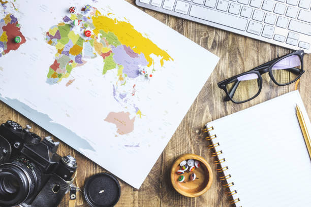 istock World map, pins with flags, retro camera, sunglasses, notepad, flower. Flat lay vacation travel planning composition. Travel photographer concept. 1186946565