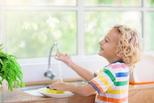 istock Child washing dishes. 1186946722