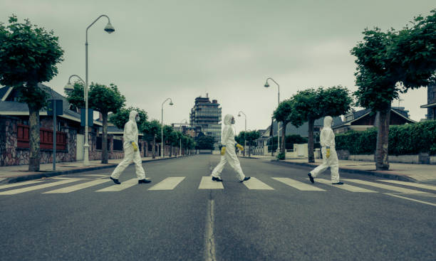 People with bacteriological protection suits in a crosswalk