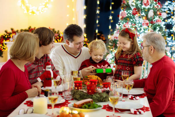 istock Family with kids having Christmas dinner at tree 1186947135