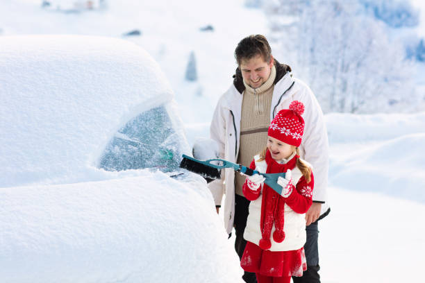 istock Father and child brushing off car in winter. 1186947356