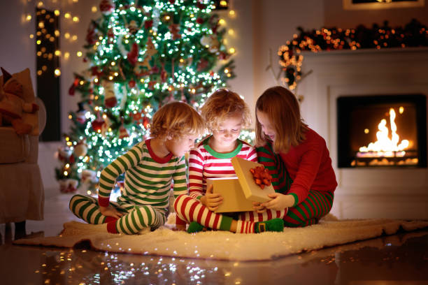 enfant à l'arbre de noel. gosses à la cheminée sur noel - christmas child baby surprise photos et images de collection