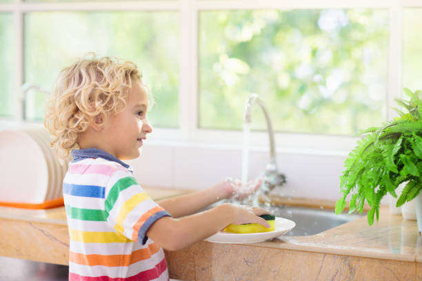 istock Child washing dishes. 1186949597
