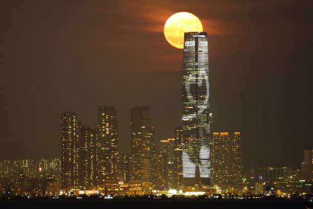 Moon rise in Hong Kong This photo captures a moon rise in Hong Kong, taken from 12km west of the tallest building - International Commerce Centre, so the moon appears to be very big. hong kong moon night stock pictures, royalty-free photos & images