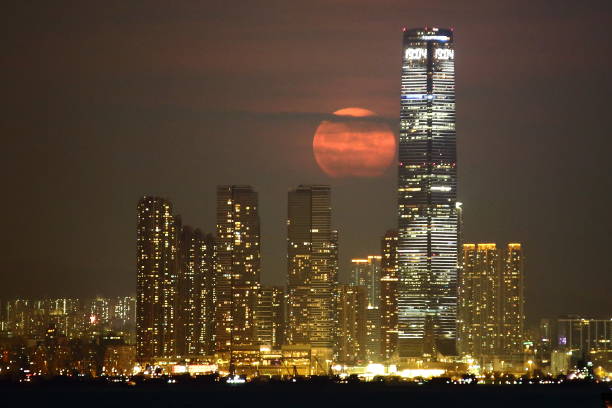 Moon rise in Hong Kong This photo captures a moon rise in Hong Kong, taken from 12km west of the tallest building - International Commerce Centre, so the moon appears to be very big. hong kong moon night stock pictures, royalty-free photos & images