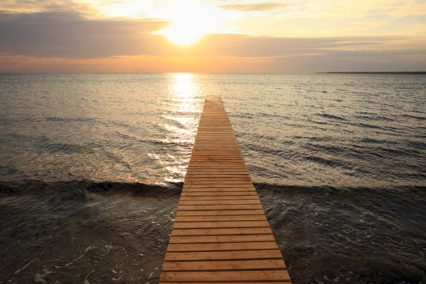 wooden pier at Black sea ldirected towards the sun.