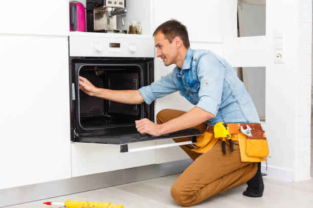 istock Young Repairman Installing Induction Cooker In Kitchen 1186954680