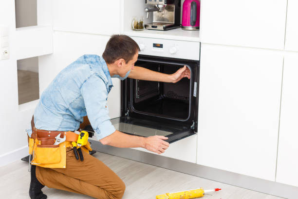 istock Young Repairman Installing Induction Cooker In Kitchen 1186954894
