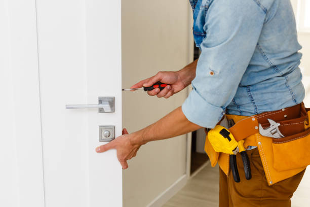 young repairman checking new door lock young repairman checking new door lock door lock stock pictures, royalty-free photos & images