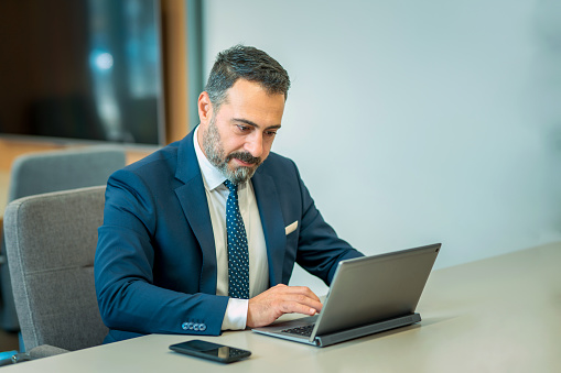 A suit-wearing, bearded and handsome employee who trades on his computer