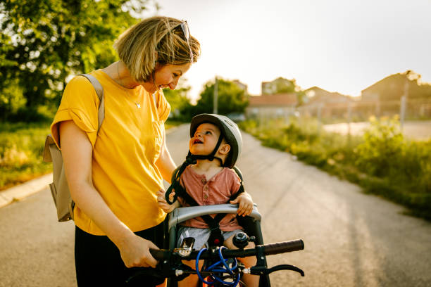 il bambino si gode il giro in bicicletta con sua madre - baby mother summer park foto e immagini stock